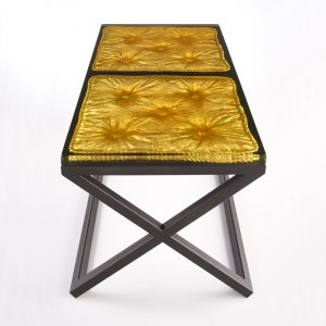 cast resin imprint of a cushion set into a metal frame/base with gilded detail